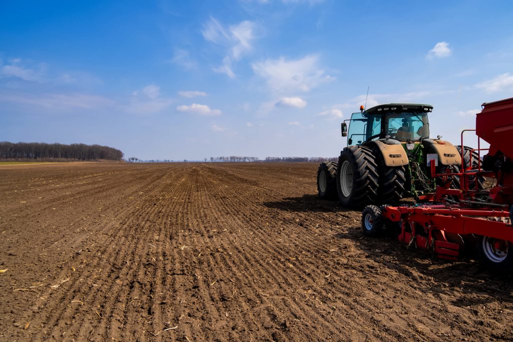 tractor with planter in the field in early spring